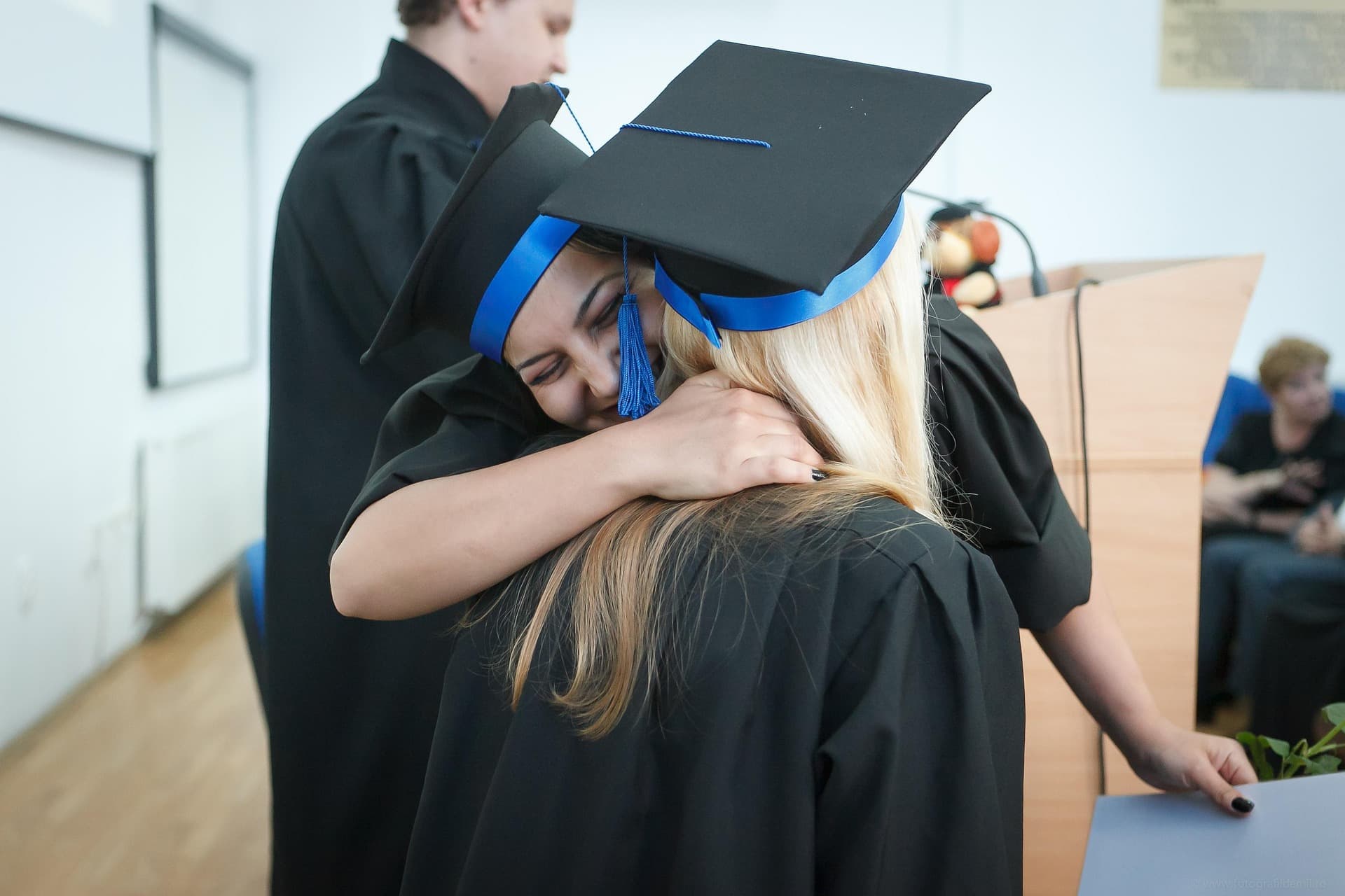 Graduate in a cap and gown standing outdoors